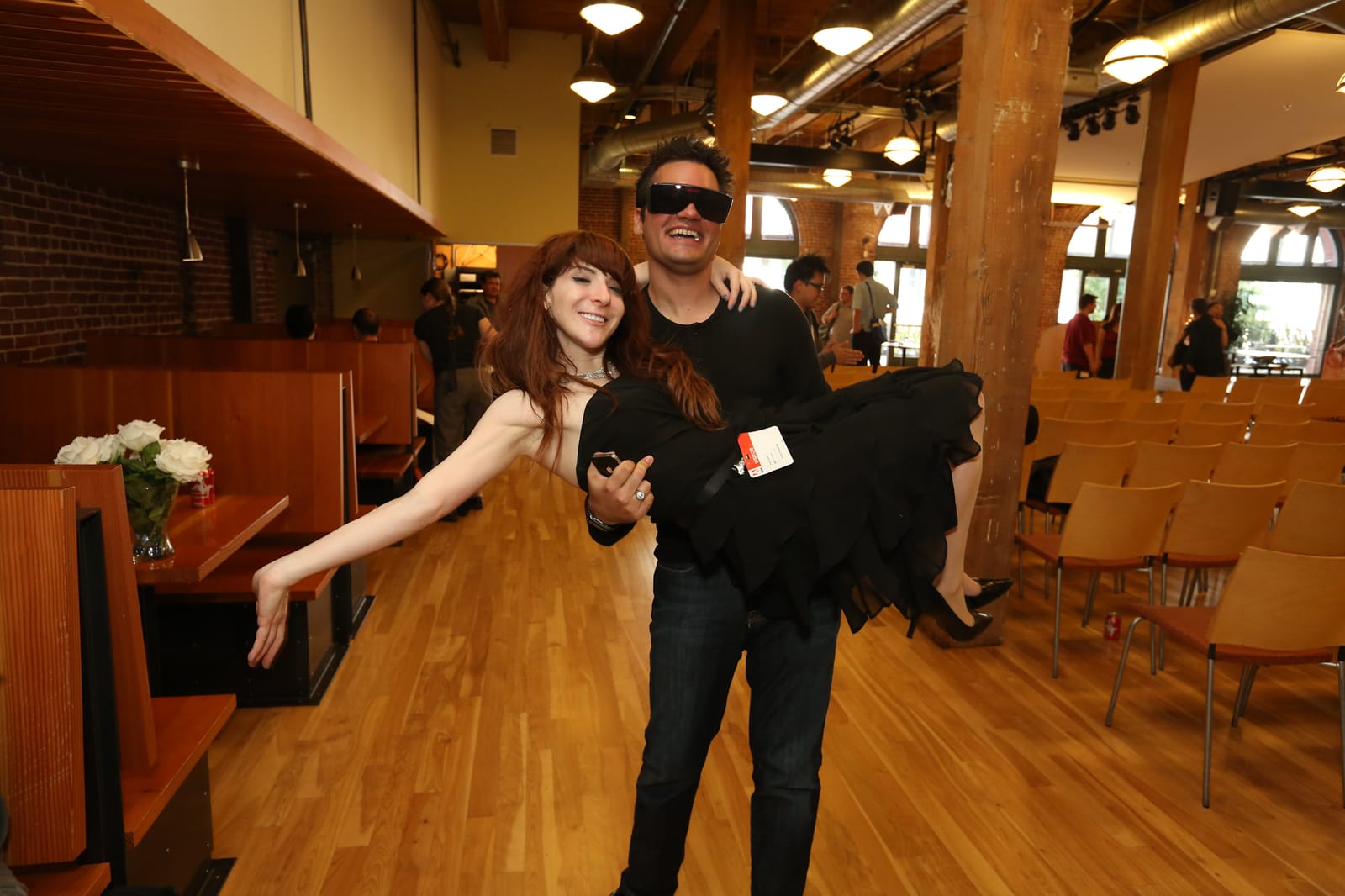 A playful candid of an attendee carrying Andi Galpern in a loft event venue